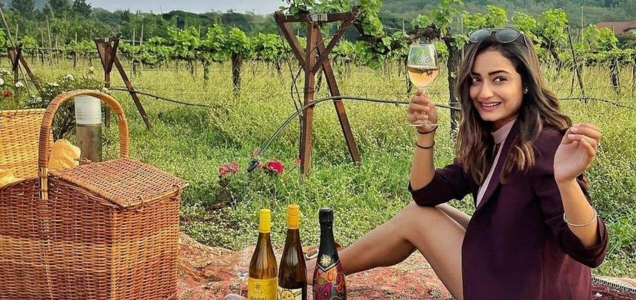 a girl holding wine glass and picnic